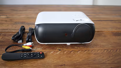 Elegimos los mejores proyectores portátiles para ver películas Proyector portátil en una mesa de madera.